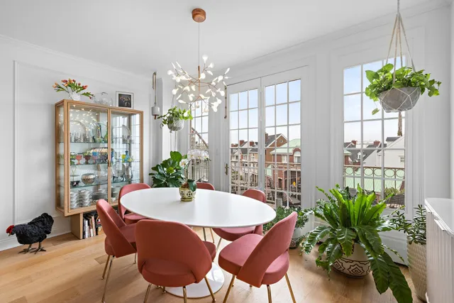 a dining room with furniture potted plants and a chandelier