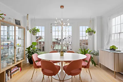 a dining room with furniture a chandelier and wooden floor