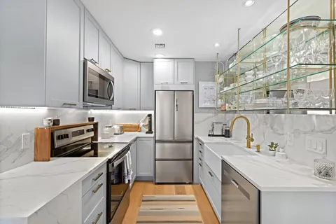 a kitchen with stainless steel appliances a refrigerator sink and microwave