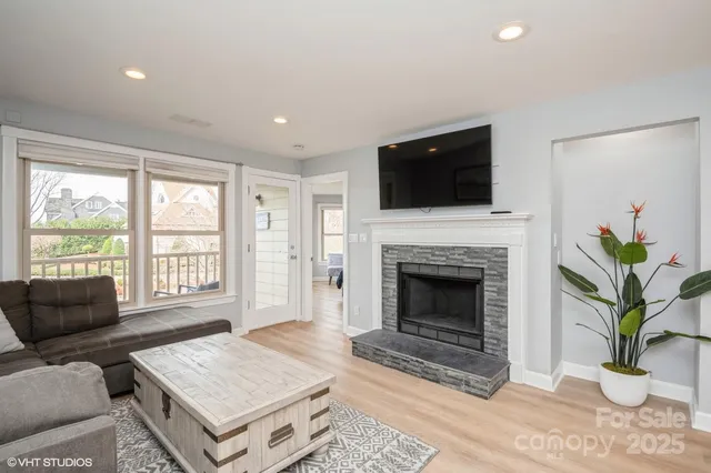 a living room with furniture a fireplace and a flat screen tv