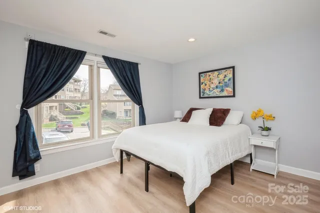 a bedroom with a bed and a large window