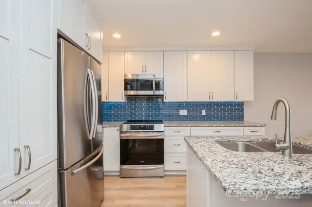 a kitchen with a refrigerator sink and cabinets