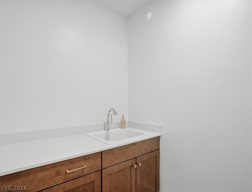 9725 Starlight Ridge Avenue Las Vegas, NV 89148 - Photo 36 of 47 This spacious laundry room offers a functional layout with ample counter space and a convenient sink.