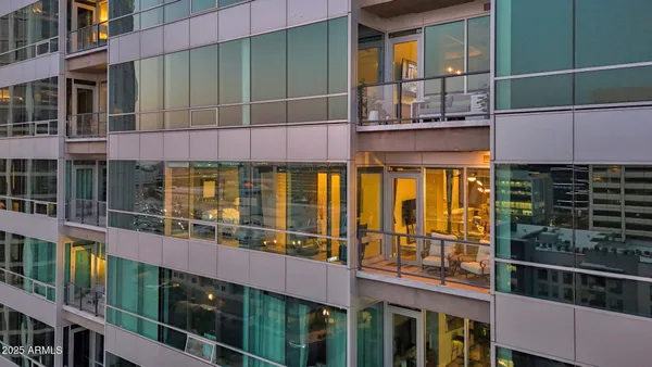 a kitchen with stainless steel appliances kitchen island granite countertop a refrigerator a stove and white cabinets with wooden floors