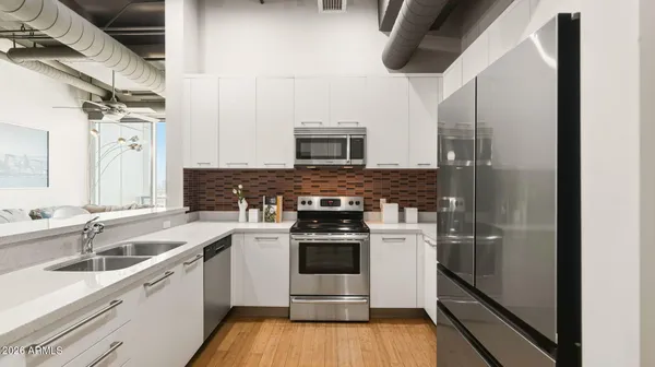 a kitchen with stainless steel appliances a stove a sink and a refrigerator