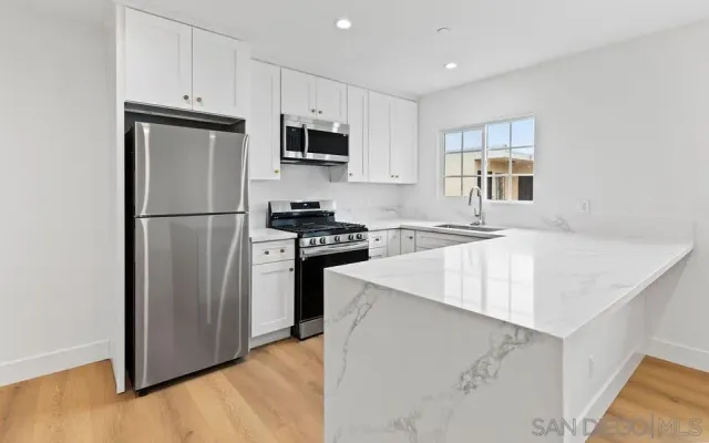 a kitchen with white cabinets and stainless steel appliances