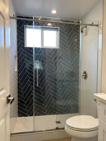 a bathroom with a toilet and a shower