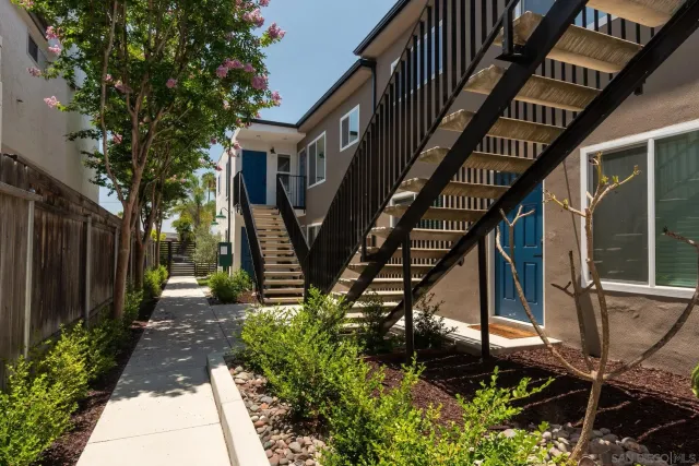 a view of a white house with a garden and balcony