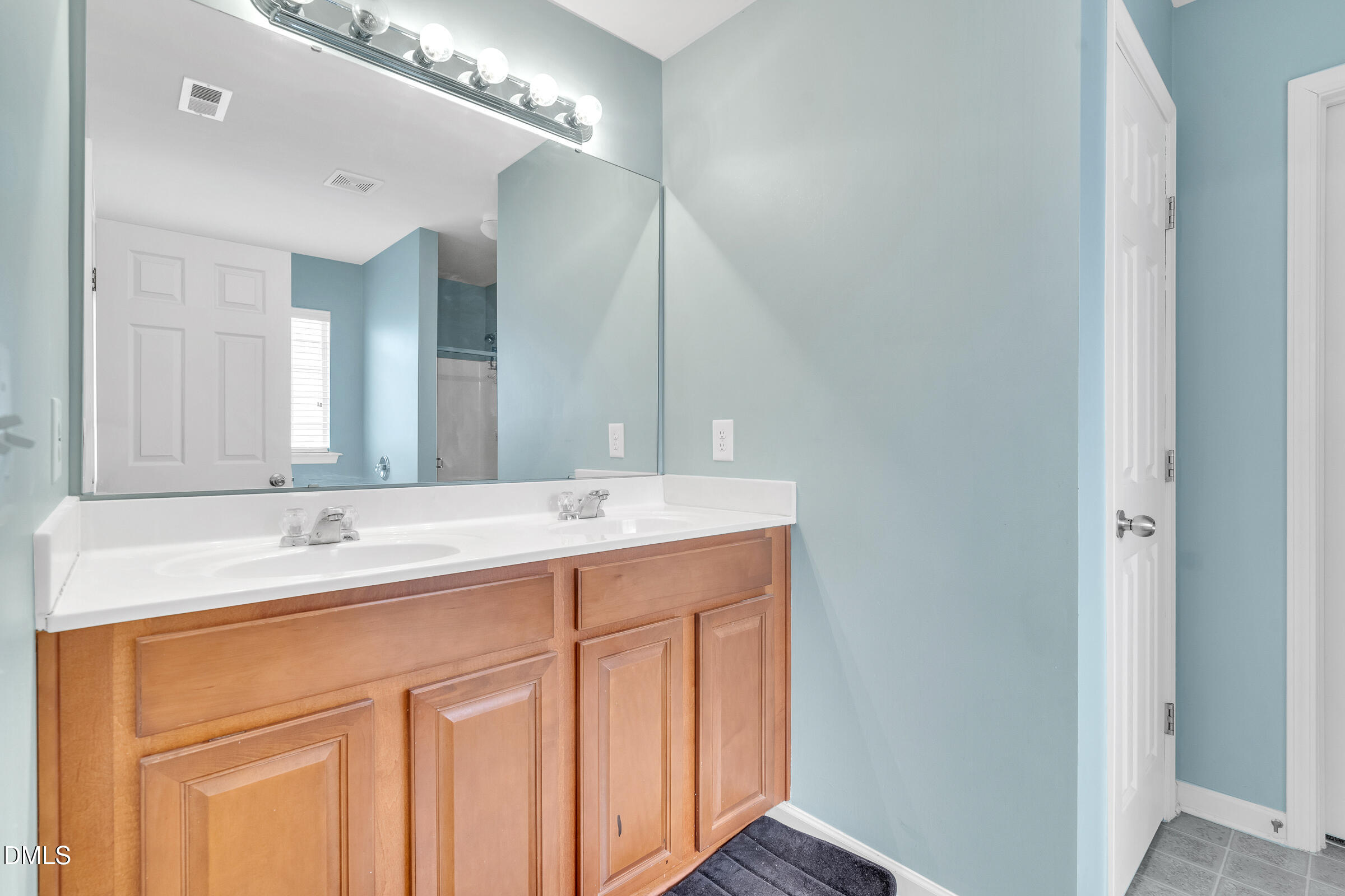 5165 Busted Rock Trail Raleigh, NC 27610 - Photo 14 of 18 a bathroom with a double vanity sink and a mirror