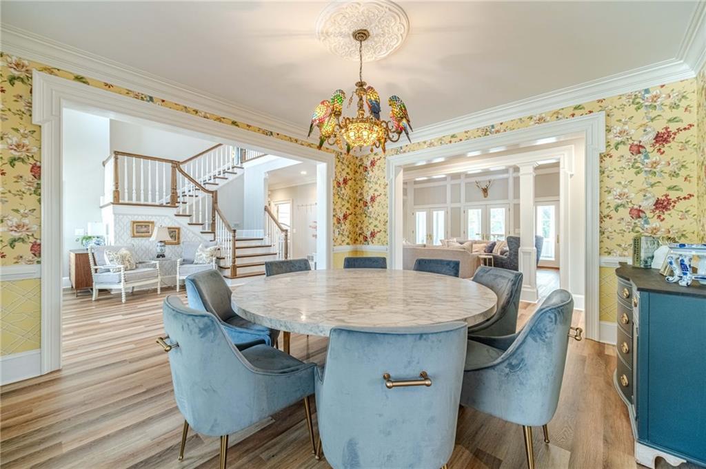 1271 Carl Davis Road Northwest Monroe, GA 30656 - Photo 11 of 80 a dining room with wooden floor a chandelier a wooden table and chairs