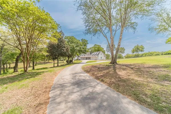 a dining room with wooden floor a chandelier a wooden table and chairs