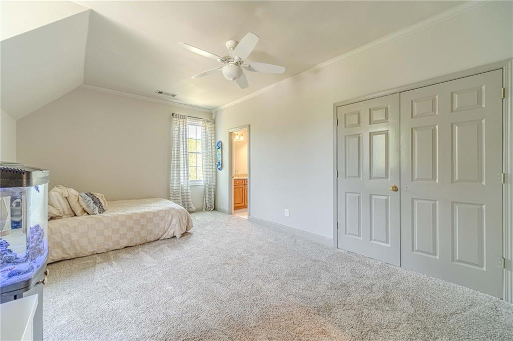1271 Carl Davis Road Northwest Monroe, GA 30656 - Photo 49 of 80 a spacious bedroom with a bed and a chandelier