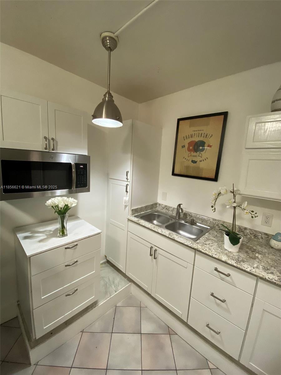 701 Hollywood Boulevard, Unit 701 Hollywood, FL 33019 - Photo 21 of 27 a kitchen with a sink stove and cabinets
