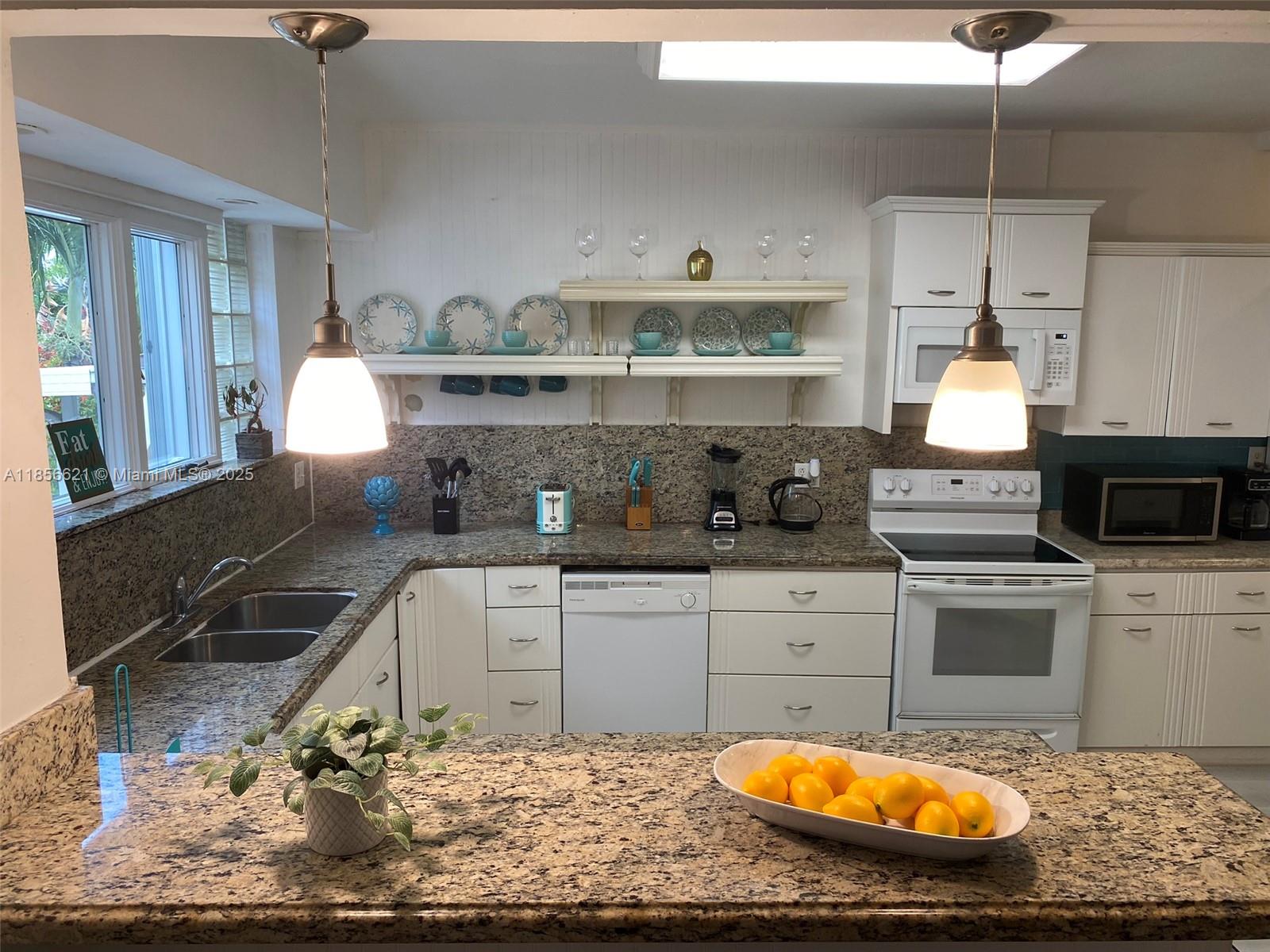 701 Hollywood Boulevard, Unit 701 Hollywood, FL 33019 - Photo 4 of 27 a kitchen with kitchen island granite countertop a sink and a stove