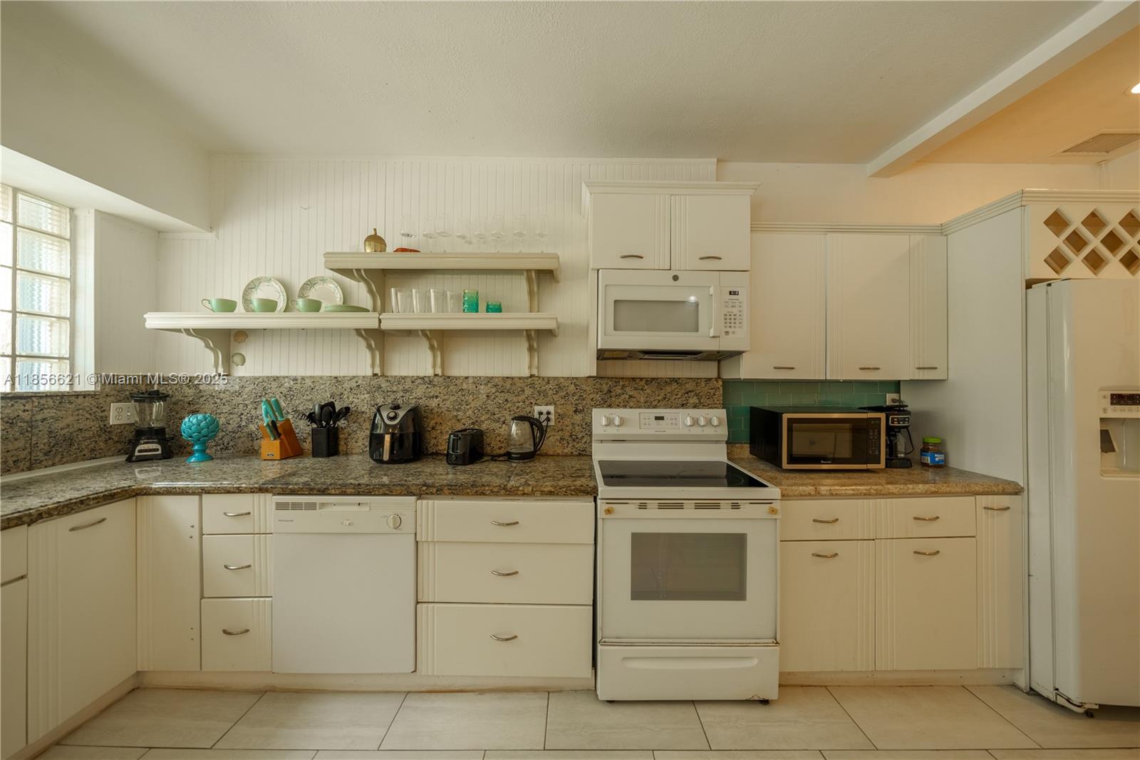 701 Hollywood Boulevard, Unit 701 Hollywood, FL 33019 - Photo 7 of 27 a kitchen with white cabinets and white appliances