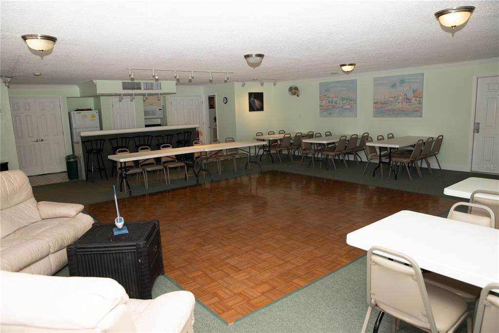 8911 Blind Pass Road, Unit 220 St. Pete Beach, FL 33706 - Photo 59 of 67 a living room with furniture a flat screen tv and kitchen view