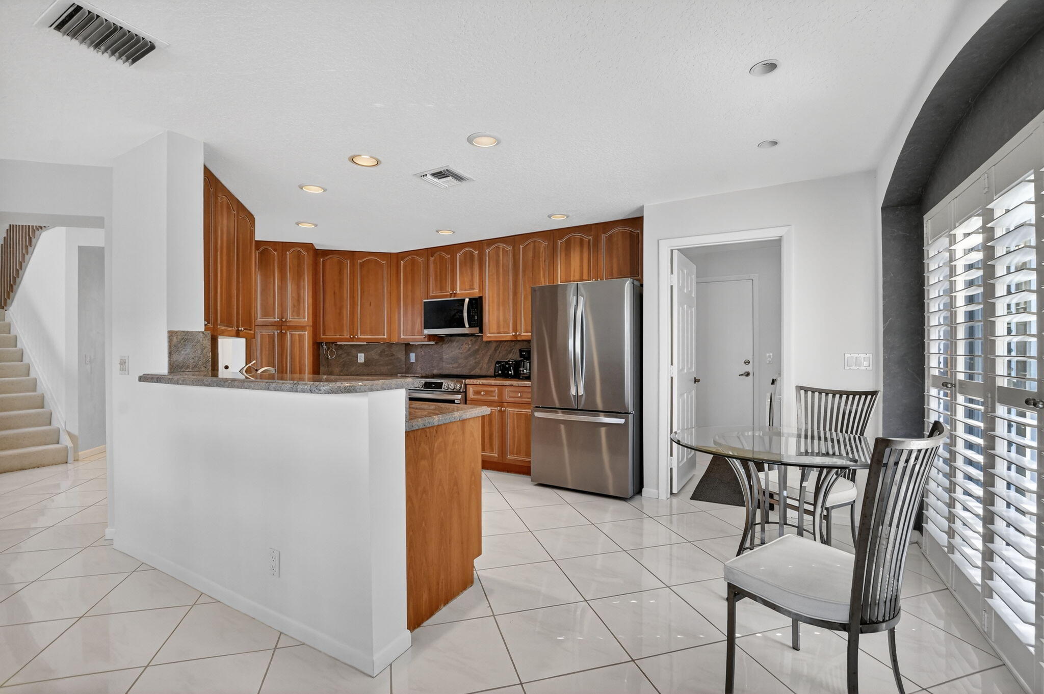23429 Rakelle Circle Boca Raton, FL 33433 - Photo 54 of 75 a kitchen with stainless steel appliances granite countertop a refrigerator and a stove top oven