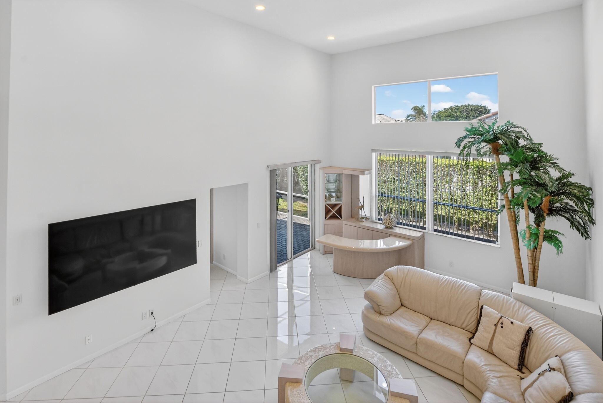 23429 Rakelle Circle Boca Raton, FL 33433 - Photo 65 of 75 a living room with furniture a flat screen tv and a floor to ceiling window