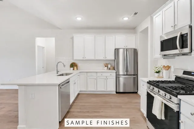 a kitchen with a sink a stove a refrigerator and cabinets