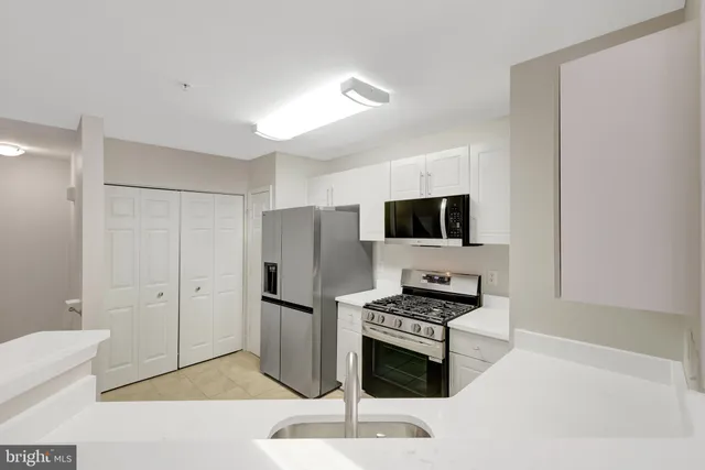 a kitchen with a refrigerator a stove a microwave and cabinets