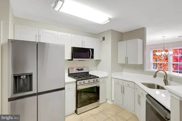 a kitchen with white cabinets stainless steel appliances and sink