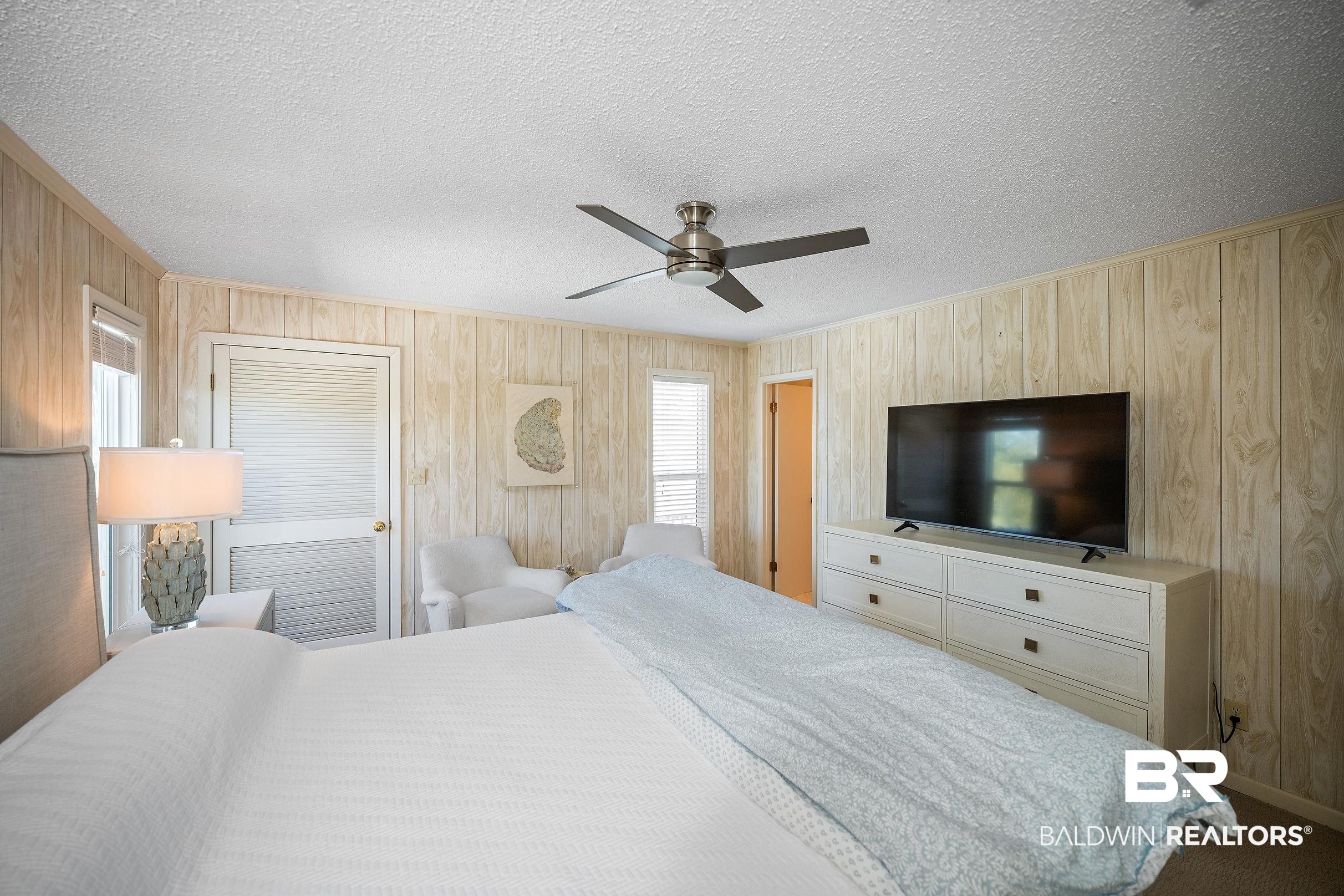 32620 River Road Orange Beach, AL 36561 - Photo 22 of 60 Bedroom featuring a textured ceiling, a ceiling fan, and wooden walls