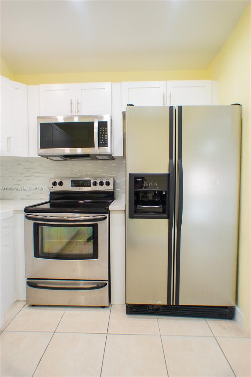 12800 Southwest 43rd Drive, Unit 210B Miami, FL 33175 - Photo 12 of 25 a kitchen with a refrigerator and a stove