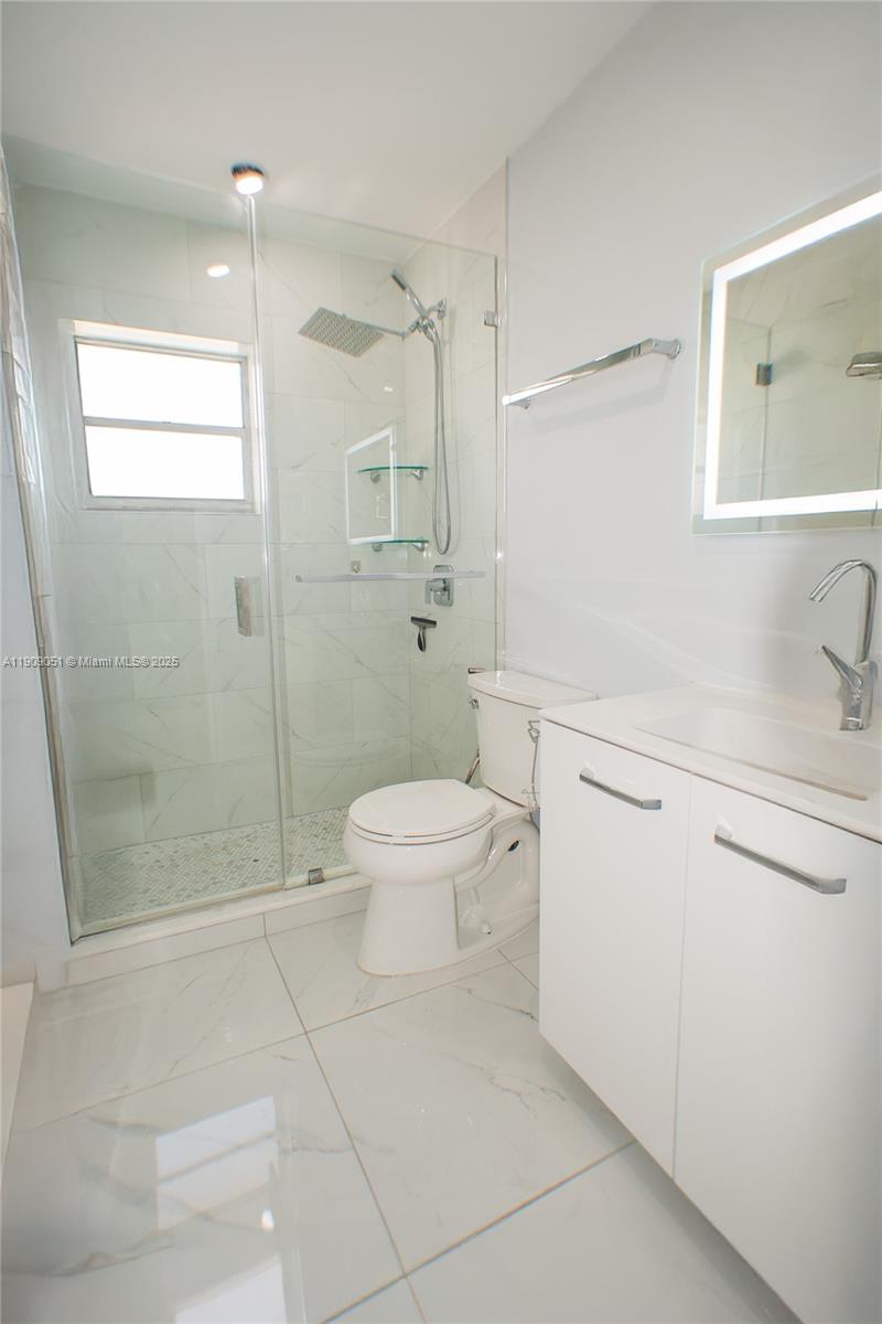 12800 Southwest 43rd Drive, Unit 210B Miami, FL 33175 - Photo 22 of 25 a bathroom with a sink a toilet and shower
