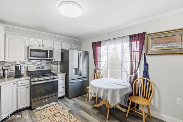 a kitchen with a table chairs refrigerator and microwave