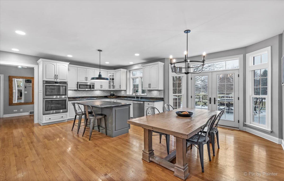 7N580 Wagontire Road St. Charles, IL 60175 - Photo 10 of 52 a kitchen with stainless steel appliances granite countertop a stove top oven a sink a dining table and chairs with wooden floor