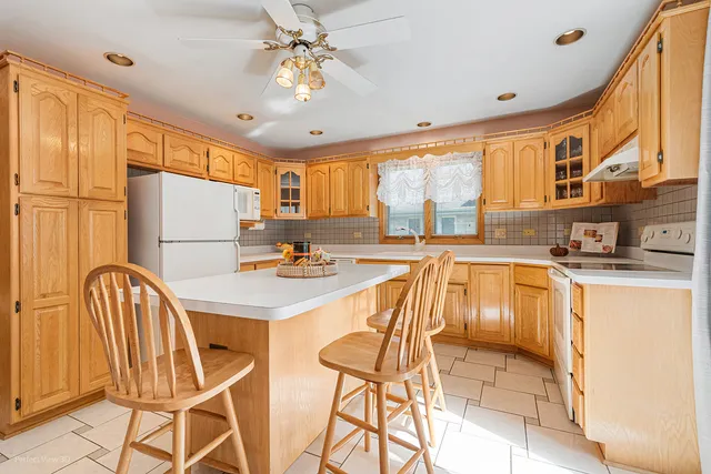 a kitchen with stainless steel appliances granite countertop a sink a stove a refrigerator with a dining table and chairs