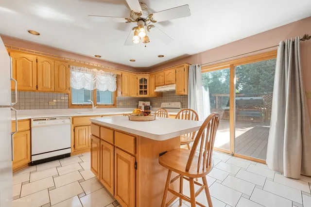 a kitchen with a stove a sink a dining table and chairs