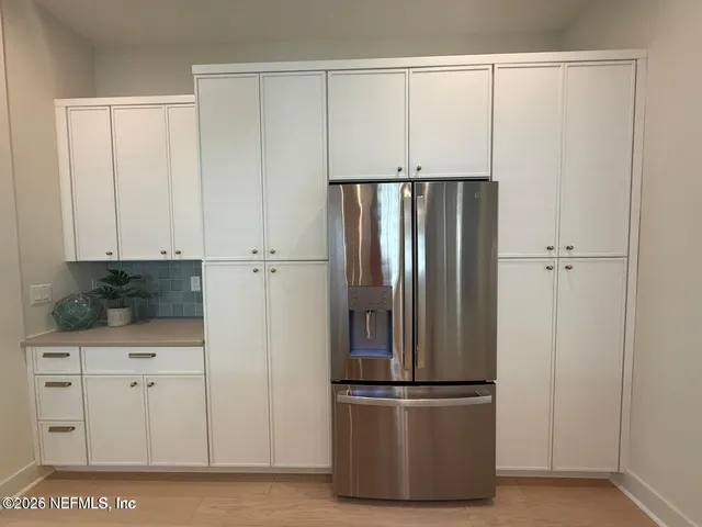 a view of kitchen with stainless steel appliances wooden cabinet and a refrigerator