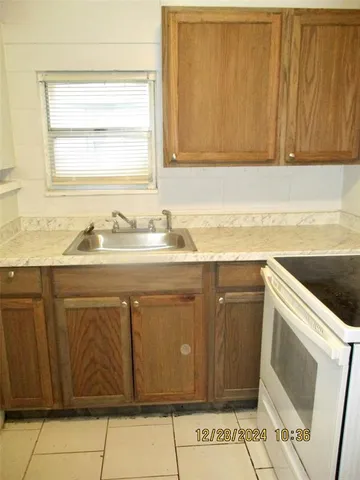 a sink with granite countertop cabinets