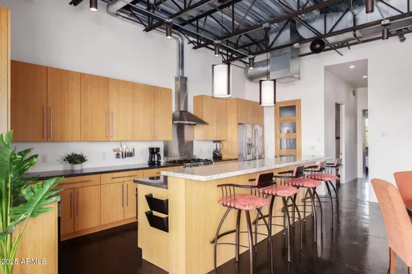 a kitchen with stainless steel appliances kitchen island granite countertop a sink stove and cabinets