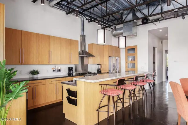 a kitchen with stainless steel appliances kitchen island granite countertop a sink stove and cabinets