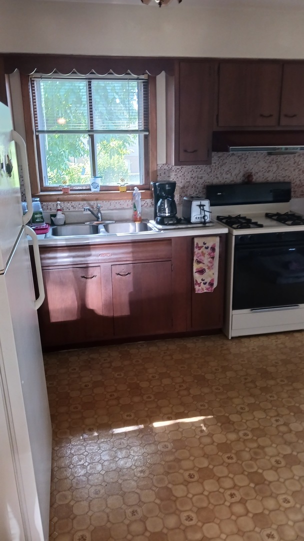 433 West Diversey Avenue Addison, IL 60101 - Photo 4 of 8 a large kitchen with granite countertop a stove a sink and a granite counter tops