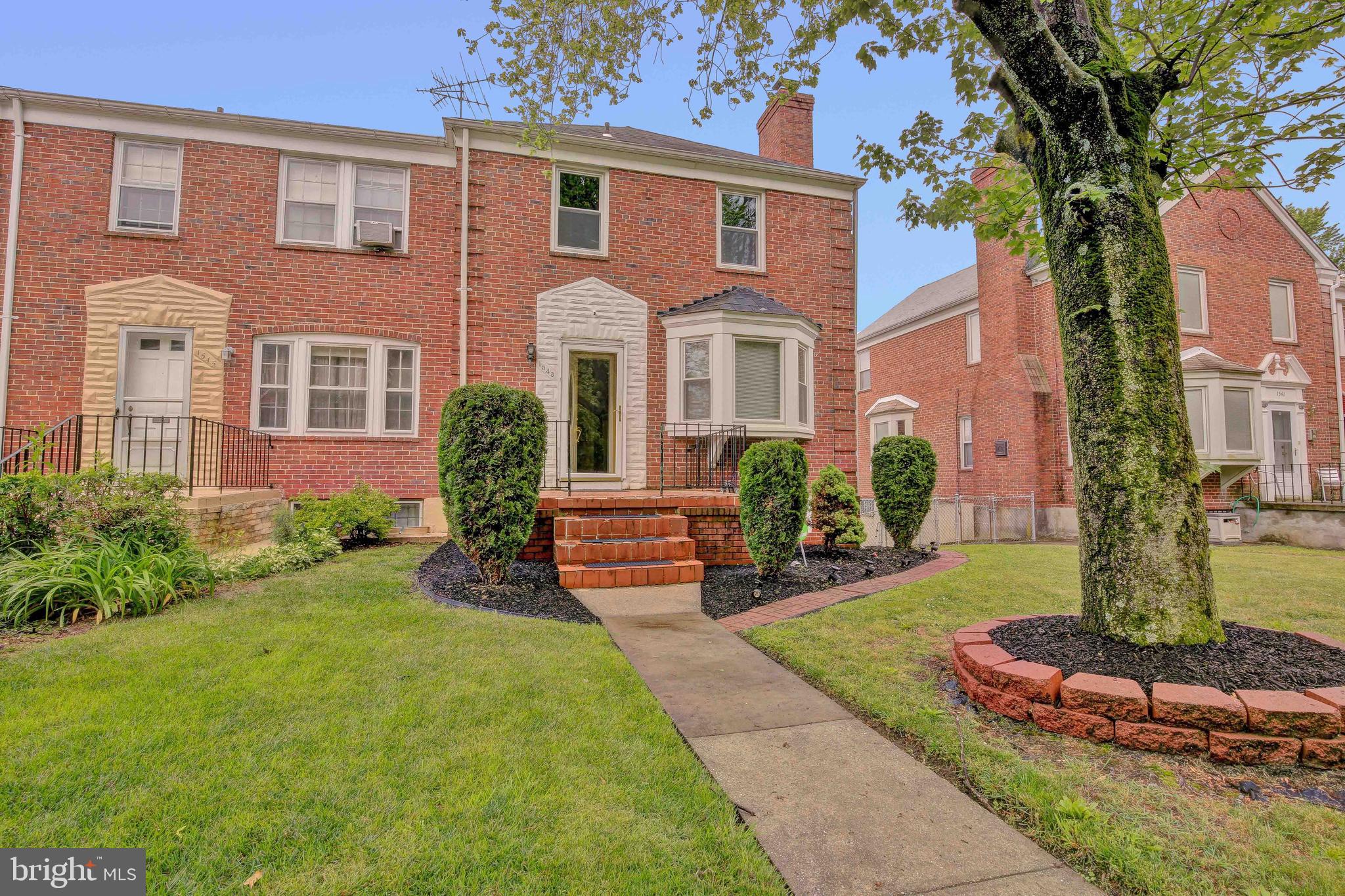 1543 Northbourne Road Baltimore, MD 21239 - Photo 1 of 20 a front view of a house with garden and trees