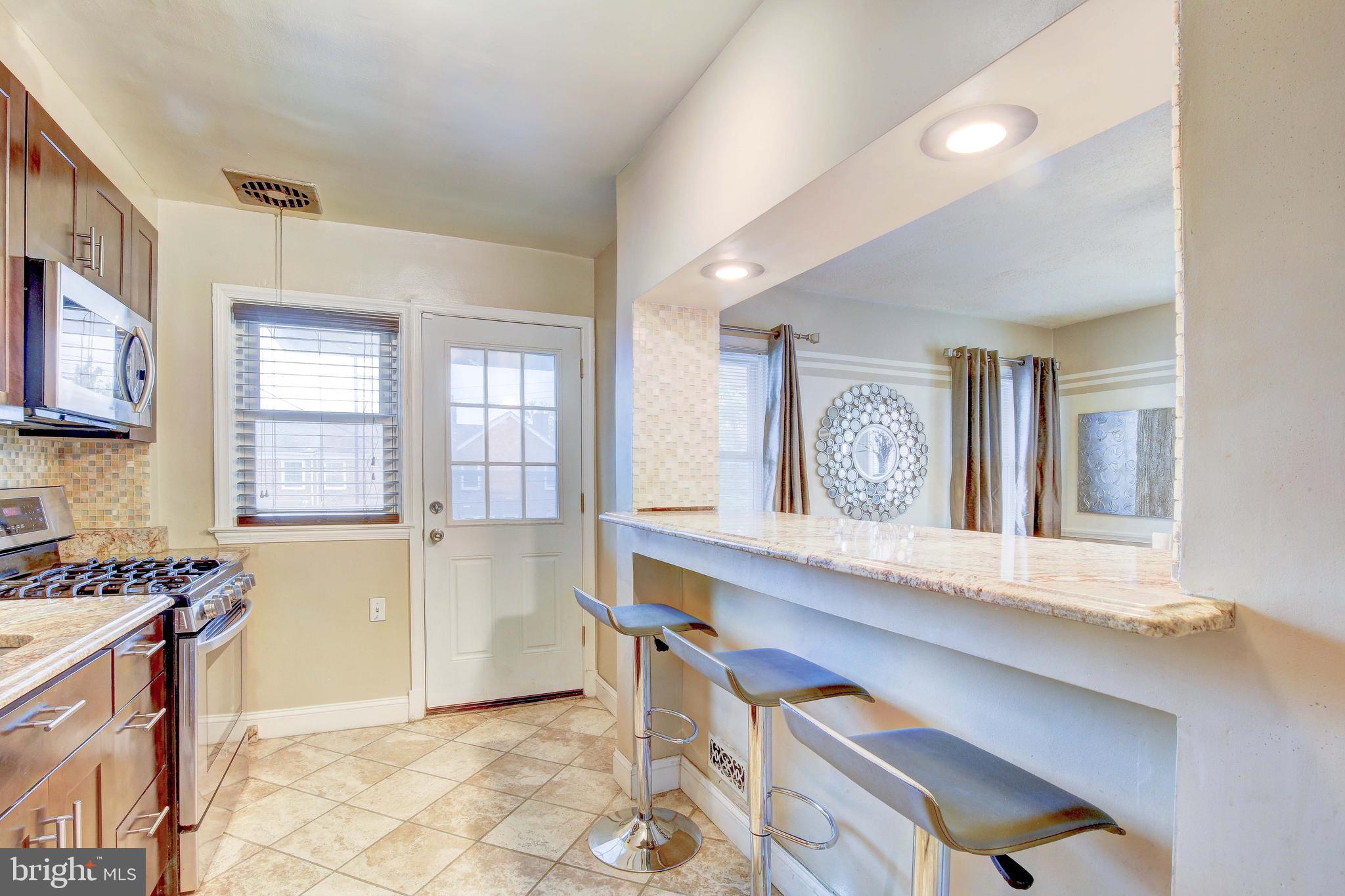 1543 Northbourne Road Baltimore, MD 21239 - Photo 9 of 20 a kitchen with a stove a refrigerator and a sink
