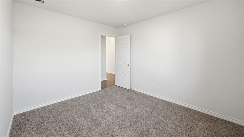 419 Epiphany Lane Lavon, TX 75166 - Photo 24 of 31 Spacious room featuring neutral carpeting, white walls, and white baseboards