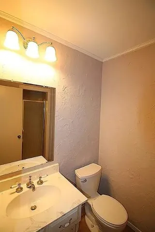 a bathroom with a sink mirror vanity and toilet
