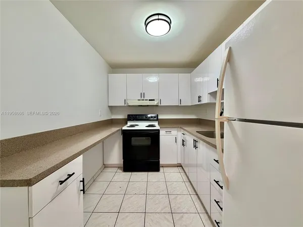 a kitchen with granite countertop a stove sink and cabinets