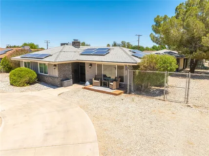 a view of a white house with a outdoor space and sitting area