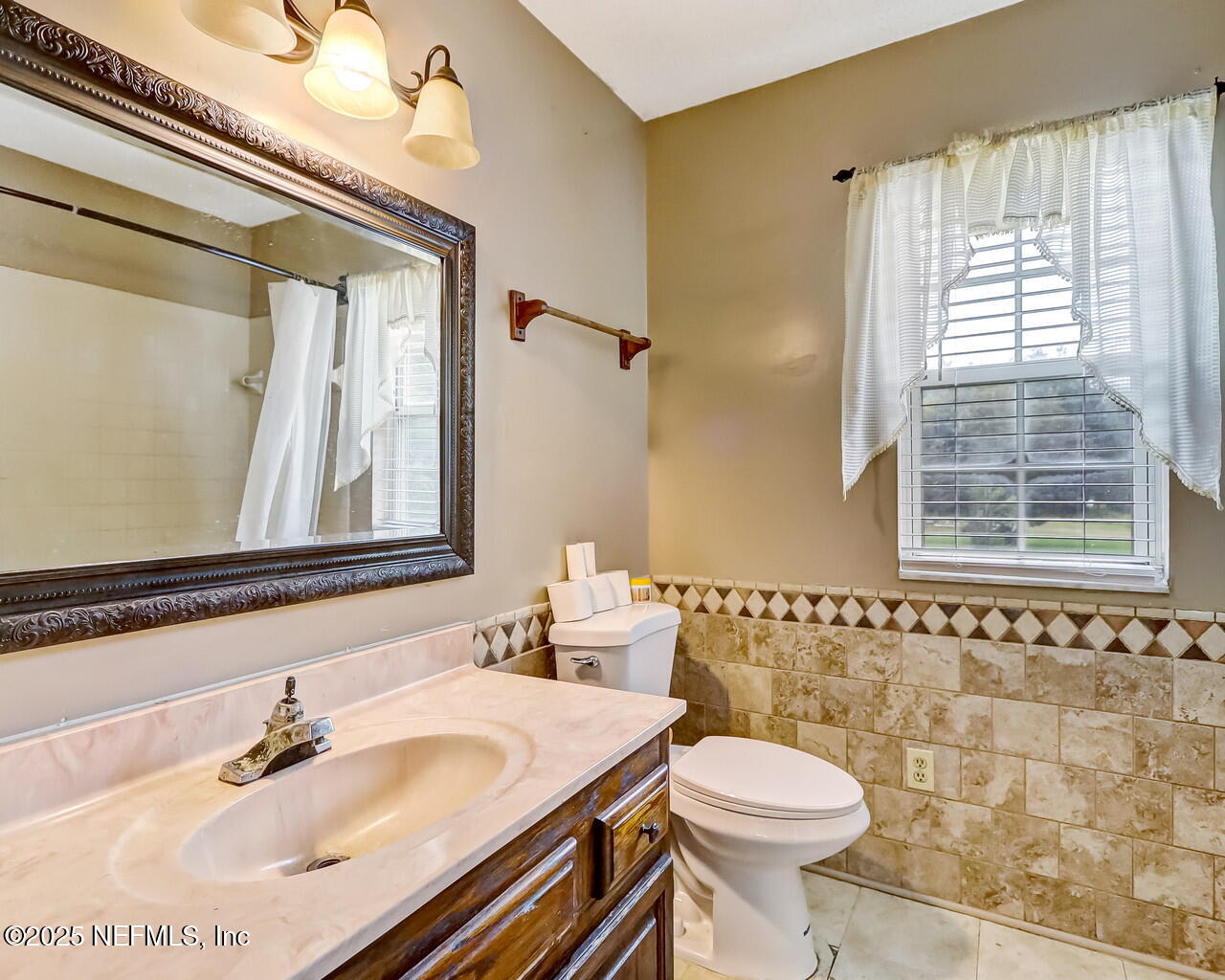 43059 Pearl Lane Callahan, FL 32011 - Photo 30 of 42 a bathroom with a sink a toilet and a mirror