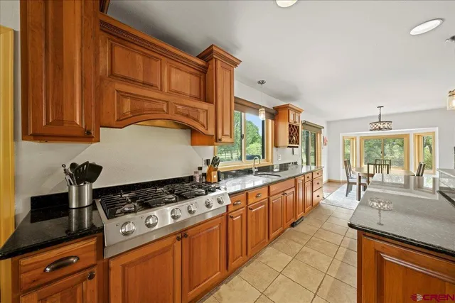 a kitchen with stainless steel appliances granite countertop a stove a sink and a microwave