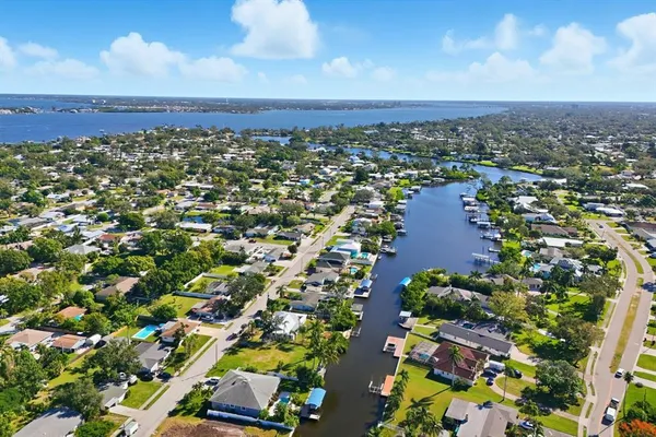 an aerial view of residential houses with outdoor space and trees all around