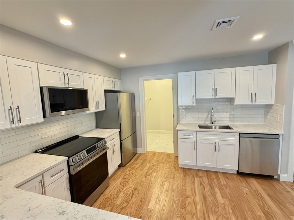 22 Barracks Road, Unit 22 Hudson, MA 01749 - Photo 2 of 15 a kitchen with stainless steel appliances granite countertop a stove a sink and a refrigerator