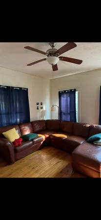a room with wooden floor pool table and chairs