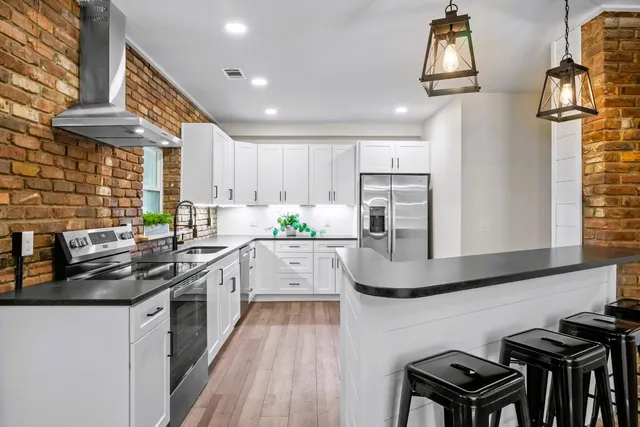 a kitchen with stainless steel appliances granite countertop a sink stove and cabinets