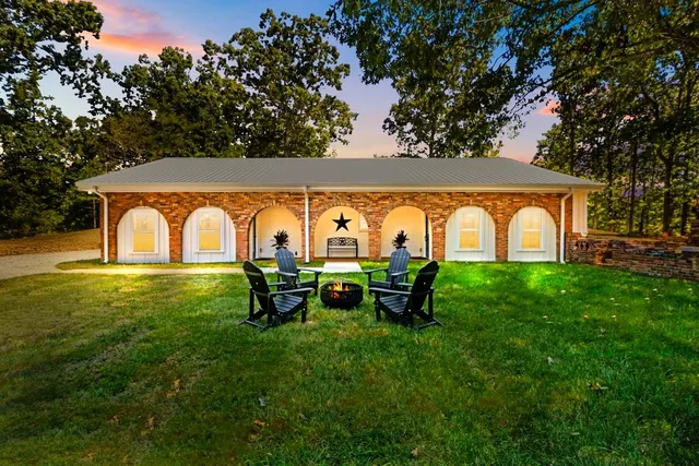 an aerial view of residential houses with outdoor space and trees